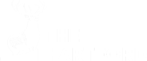 White logo of The Hartford featuring a standing stag silhouette on a small platform at left and the words THE HARTFORD in bold uppercase to the right