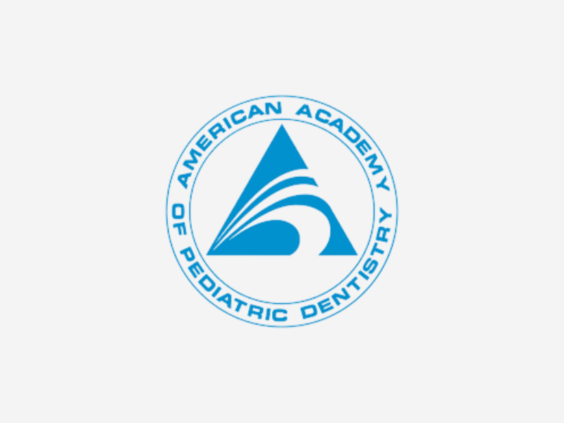Blue circular logo featuring a stylized triangular swoosh design in the center and the words American Academy of Pediatric Dentistry around the outer ring.